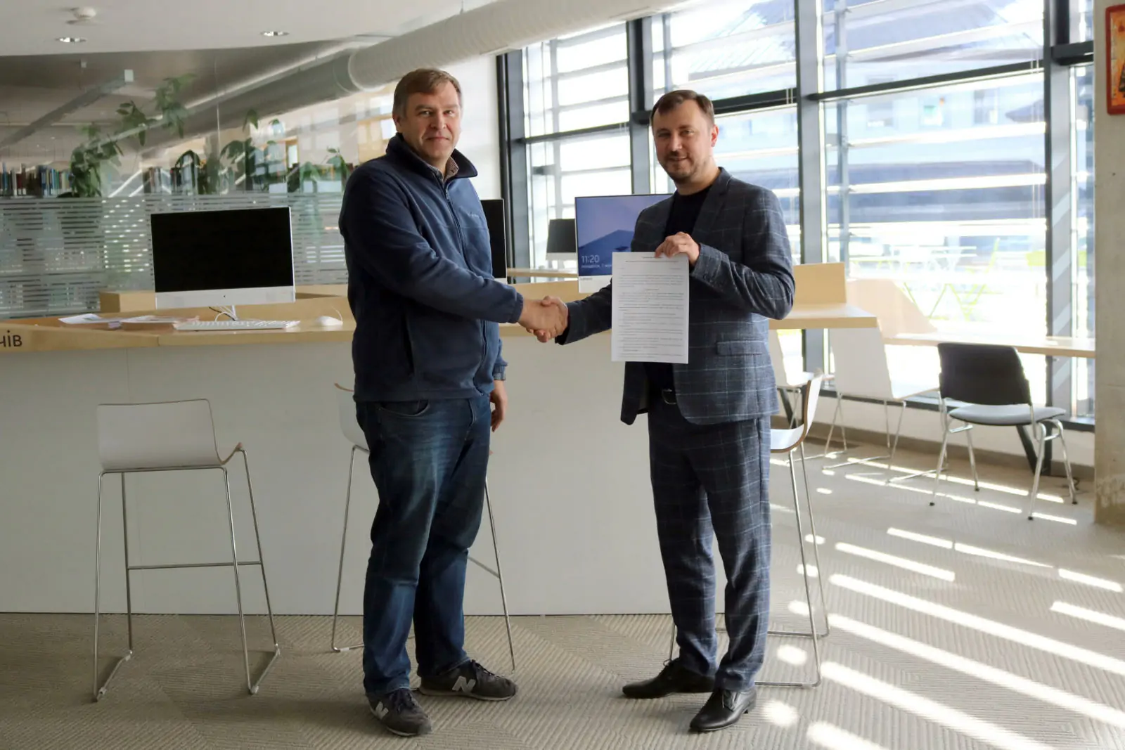 Yaroslav Prytula, Dean of Faculty of Applied Sciences at UCU (to the left), and Ihor Salamin, Human Capital Director at PLVision (to the right), welcome the signing of the collaboration agreement between their organizations. 